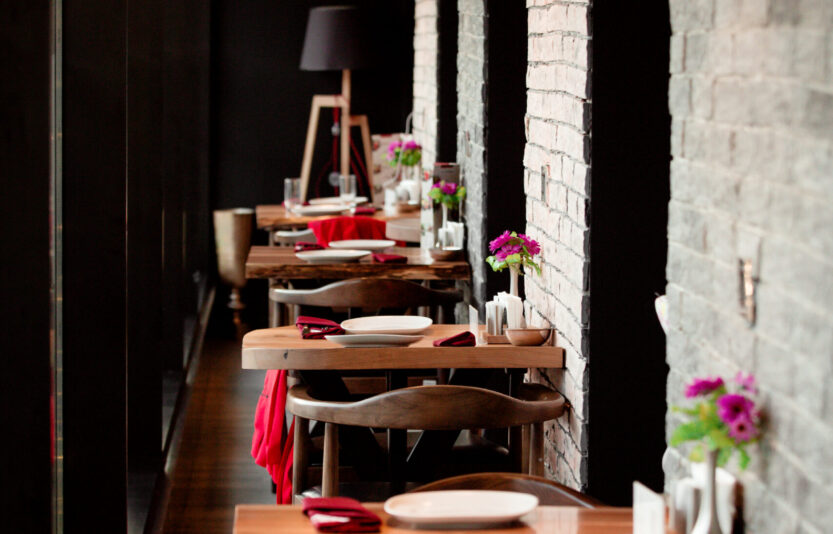 a restaurant corridor with small two people tables a restaurant corridor with small two people tables